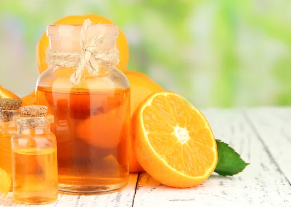 Olio essenziale di mandarino e mandarini sul tavolo di legno, sullo sfondo della natura — Foto Stock