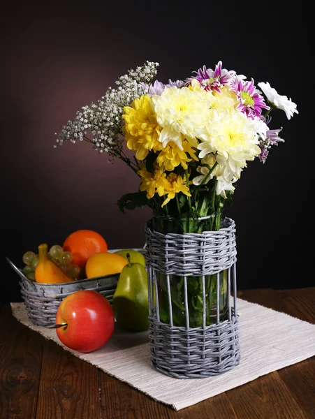 Beautiful chrysanthemum flowers in vase on table on brown background — Stock Photo, Image