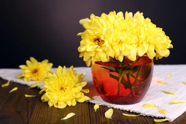Vackra chrysanthemum blommor i vas på bordet på mörk bakgrund — Stockfoto