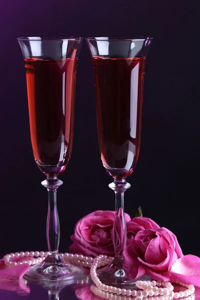 Composition with pink wine in glasses and roses on dark color background Royalty Free Stock Photos