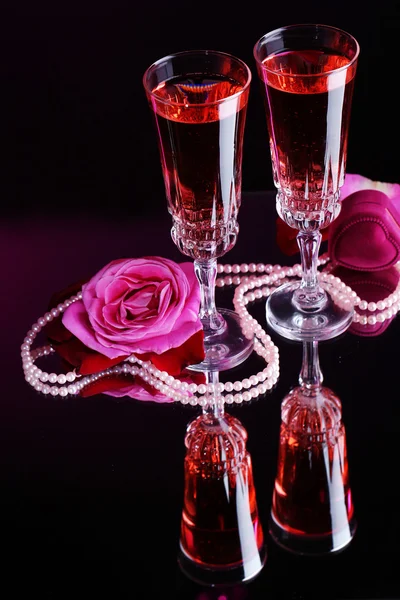 Composition with pink wine in glasses and roses on dark color background Stock Image