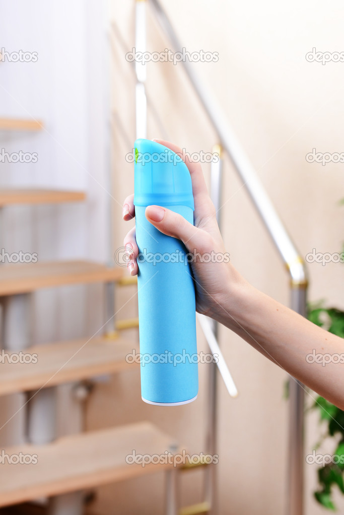 Sprayed air freshener in hand close-up