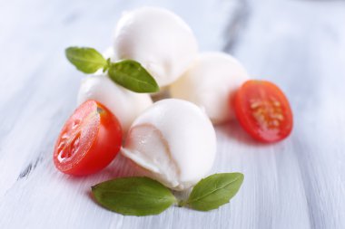 ahşap masa üstünde domates ve fesleğen ile lezzetli mozzarella peyniri