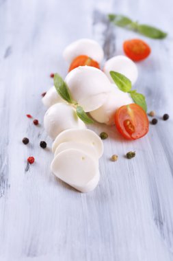 ahşap masa üstünde domates ve fesleğen ile lezzetli mozzarella peyniri
