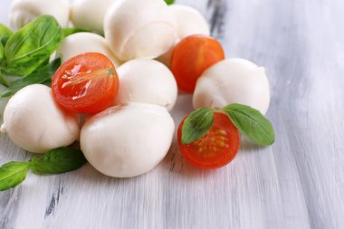 ahşap masa üstünde domates ve fesleğen ile lezzetli mozzarella peyniri
