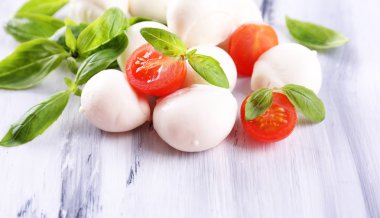 ahşap masa üstünde domates ve fesleğen ile lezzetli mozzarella peyniri