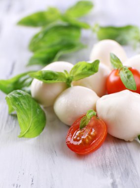 ahşap masa üstünde domates ve fesleğen ile lezzetli mozzarella peyniri