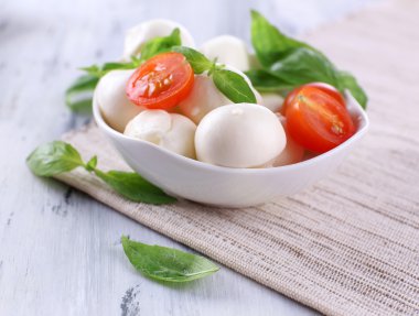kase, ahşap masa üstünde domates ve fesleğen ile lezzetli mozzarella peyniri