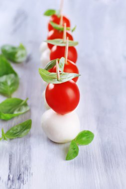 ahşap masa üstünde domates ve fesleğen ile lezzetli mozzarella peyniri