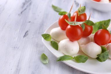 ahşap masa tabakta domates ve fesleğen ile lezzetli mozzarella peyniri