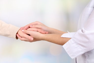 açık renkli hastanın elini tutarak tıp doktoru