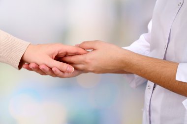 açık renkli hastanın elini tutarak tıp doktoru