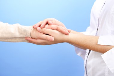açık renkli hastanın elini tutarak tıp doktoru