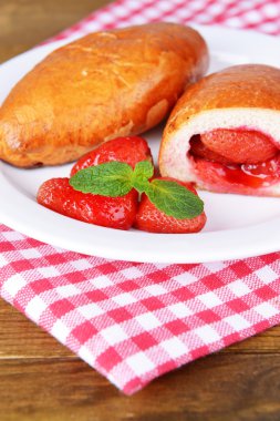 taze pişmiş pasties plaka üzerinde tablo close-up çilekleri ile