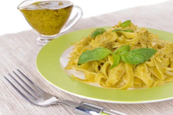 Massa deliciosa com pesto no prato na mesa close-up — Fotografia de Stock