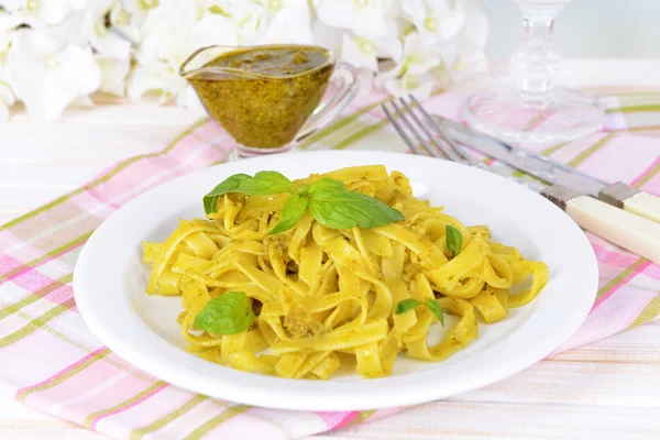 Läckra pasta med pesto på tallriken på bordet närbild — Stockfoto