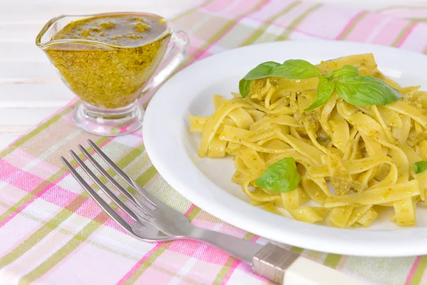 Delicious pasta with pesto on plate on table close-up — Stock Photo, Image