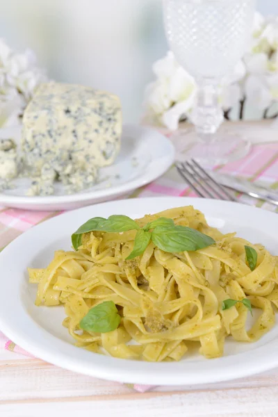 Läckra pasta med pesto på tallriken på bordet på ljus bakgrund — Stockfoto