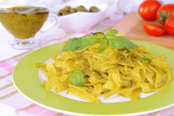 Deliciosa pasta con pesto en plato en primer plano de la mesa — Foto de Stock