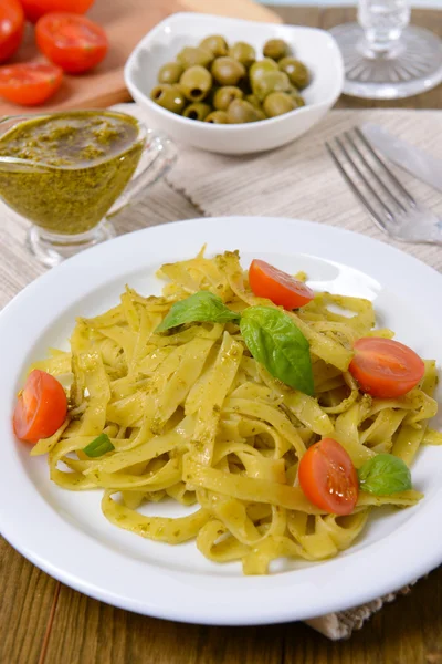 Massa deliciosa com pesto no prato na mesa close-up — Fotografia de Stock