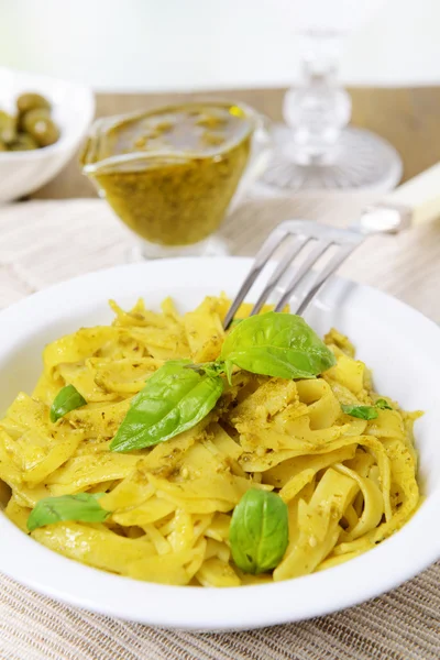 Massa deliciosa com pesto no prato na mesa close-up — Fotografia de Stock