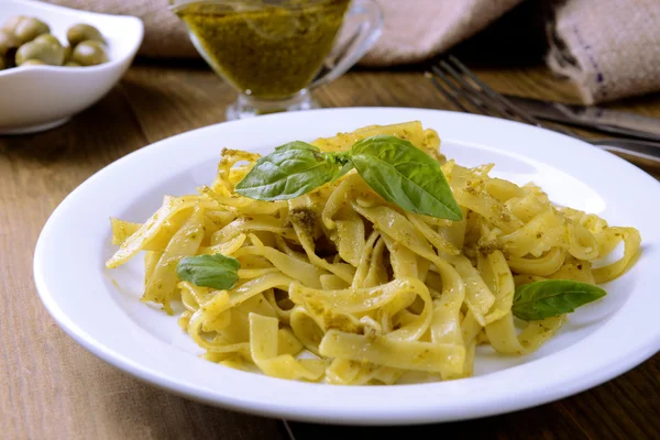 Delicious pasta with pesto on plate on table close-up — Stock Photo, Image