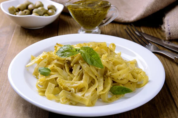 Massa deliciosa com pesto no prato na mesa close-up — Fotografia de Stock