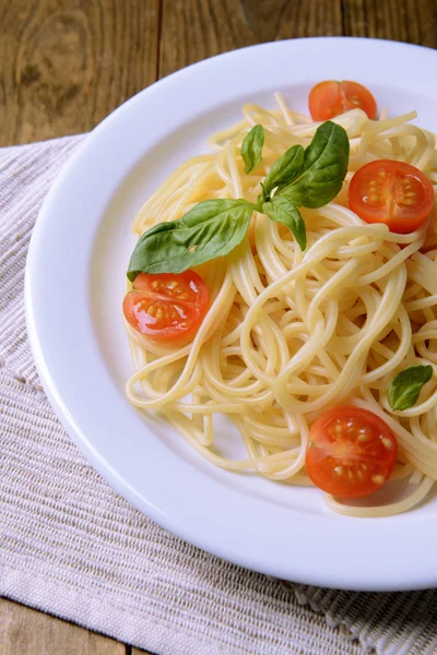 Pyszne spaghetti z pomidorami na tabliczce na stół szczegół — Zdjęcie stockowe