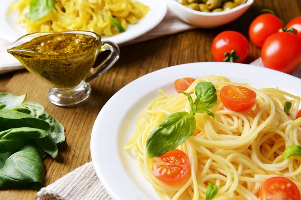 Espaguete delicioso com tomates na chapa na mesa close-up — Fotografia de Stock