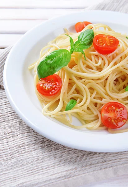 Delicious spaghetti with tomatoes on plate on table close-up — Stock Photo, Image