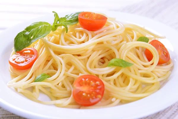 Pyszne spaghetti z pomidorami na tabliczce na stół szczegół — Zdjęcie stockowe