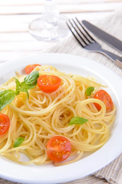 Смачна спагетті з помідорами на тарілці на столі крупним планом — стокове фото