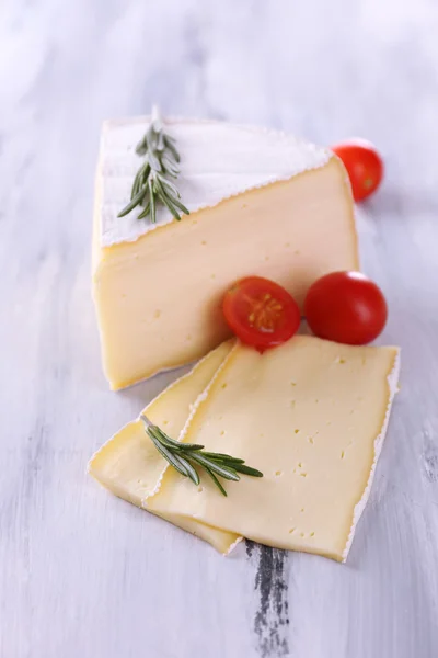 Queijo saboroso Camembert com tomate e alecrim, sobre mesa de madeira — Fotografia de Stock