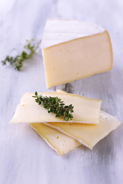 Schmackhafter Camembert-Käse mit Thymian, auf Holztisch — Stockfoto
