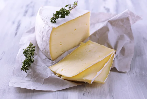 Sabroso queso Camembert con tomillo, sobre mesa de madera —  Fotos de Stock