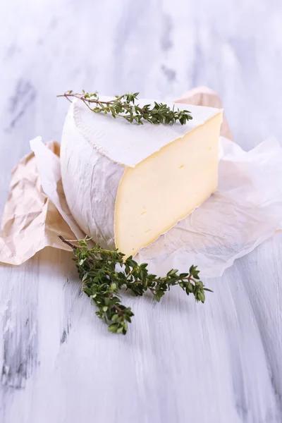 Sabroso queso Camembert con tomillo, sobre mesa de madera —  Fotos de Stock