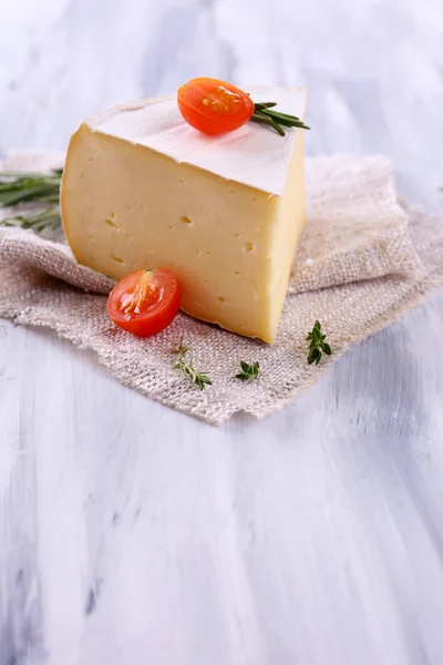 Queijo saboroso Camembert com alecrim e tomate, sobre mesa de madeira — Fotografia de Stock