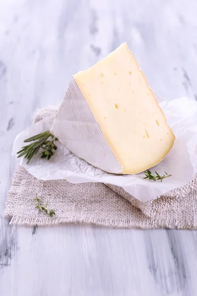 Sabroso queso Camembert con romero, sobre mesa de madera —  Fotos de Stock