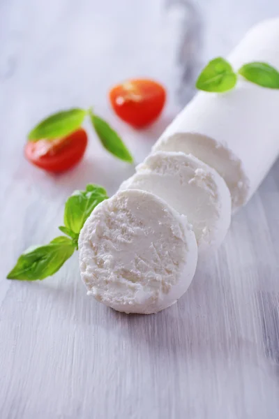 Sabroso queso de arbusto con albahaca y tomate, sobre mesa de madera — Foto de Stock