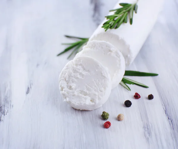 Queijo saboroso com alecrim, na mesa de madeira — Fotografia de Stock