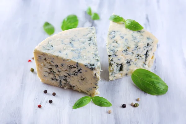 Smakelijke blauwe kaas met basilicum en specerijen op houten tafel — Stockfoto