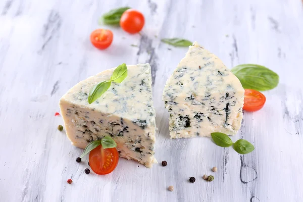 Tasty blue cheese with tomatoes, basil and spices on wooden table — Stock Photo, Image