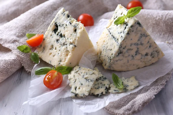 Queijo azul saboroso com tomate e manjericão sobre papel — Fotografia de Stock