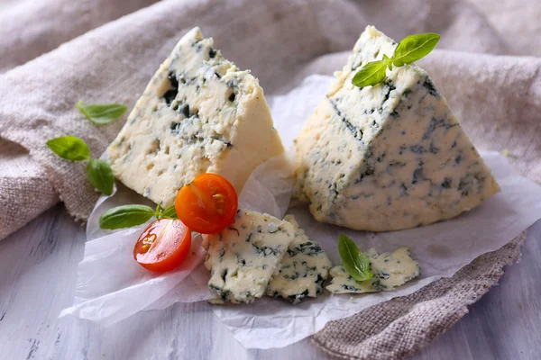 Sabroso queso azul con tomates y albahaca sobre papel — Foto de Stock