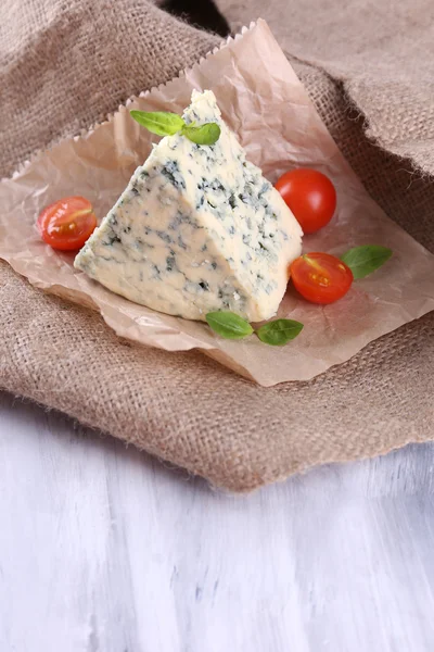Sabroso queso azul con tomates y albahaca, sobre fondo de arpillera — Foto de Stock