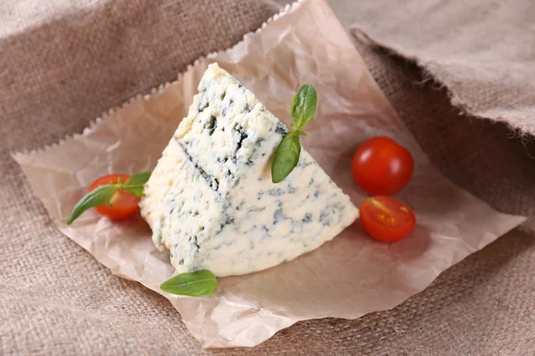 Вкусный голубой сыр с помидорами и базиликом, на фоне мешковины — стоковое фото