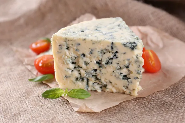 Tasty blue cheese with tomatoes and basil, on burlap background — Stock Photo, Image