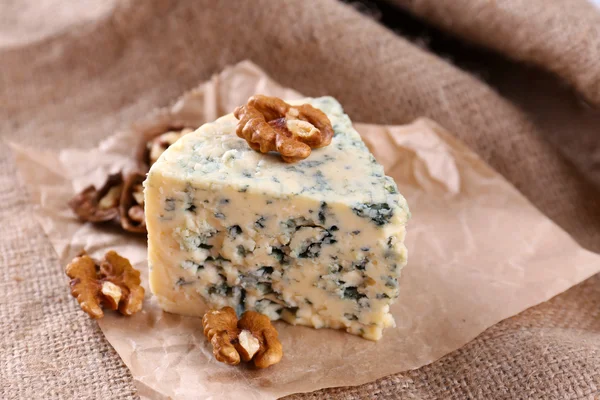 Tasty blue cheese with nuts, on burlap background — Stock Photo, Image