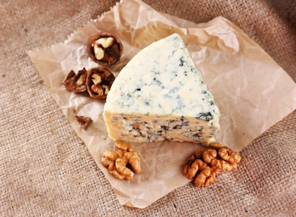 Tasty blue cheese with nuts, on burlap background — Stock Photo, Image