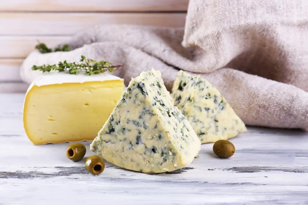 Verschillende smakelijke kaas, op houten tafel — Stockfoto